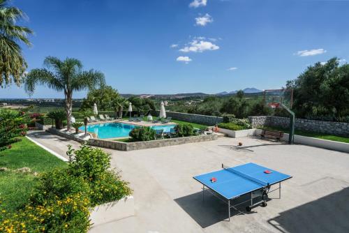 une terrasse avec une table de ping-pong et une piscine dans l'établissement Villa Anna with Private Pool, Play area & BBQ, 5km from the Beach, à Astérion