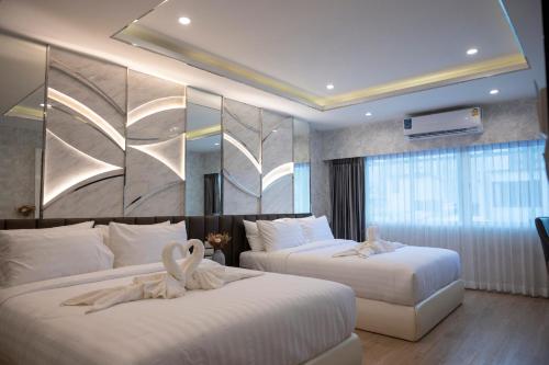 a hotel room with two beds with white sheets at Masa Hotel فندق الماسة شارع العرب in Bangkok