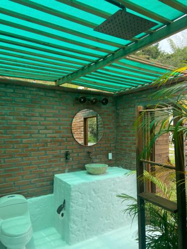 bagno con servizi igienici e specchio di Glamping La Cepa GUATAPÉ a Guatapé