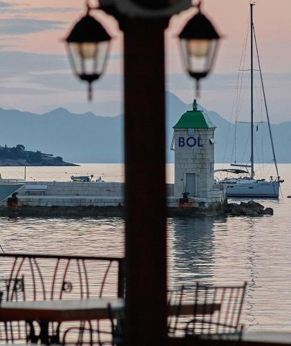 a light house on the water with a boat in the water at Guest House Marija in Bol