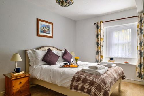 a bedroom with a bed with a tray of fruit on it at Finest Retreats - The Cottage at Greystoke in Greystoke