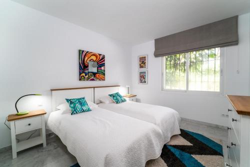 1 dormitorio blanco con 2 camas y ventana en BRIGHT NEW APARTMENT IN PUENTE ROMANO en Marbella