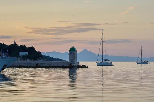 a clock tower in the middle of the water with boats at Guest House Marija in Bol