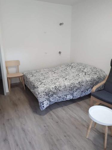 1 dormitorio con 1 cama, 1 silla y 1 mesa en Studio refait à neuf., en Mers-les-Bains