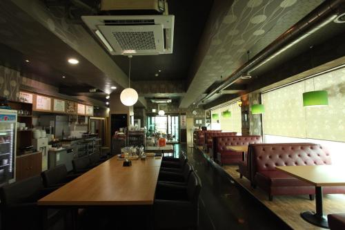a restaurant with a long table and leather chairs at Metro Pol Tourist Hotel in Pyeongtaek