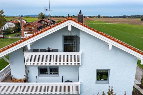 a white house with an open window and a balcony at FeWo Am Stocket in Gstadt am Chiemsee