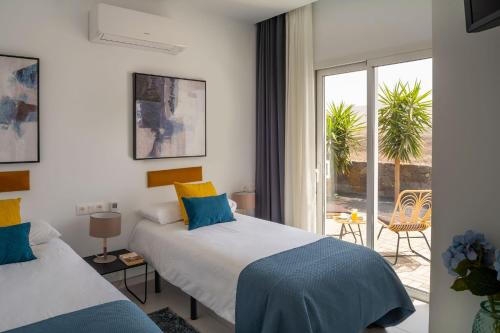 Cette chambre dispose de deux lits et d'un balcon. dans l'établissement SUNRISE by Buenavilla, à Playa Blanca