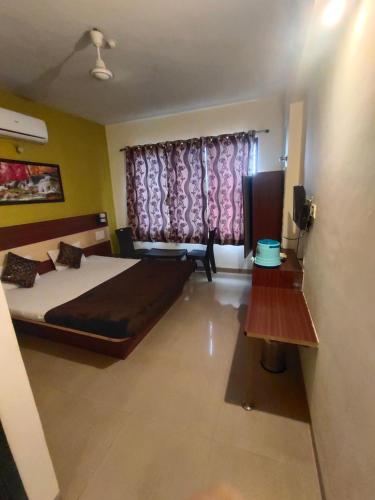 een slaapkamer met een bed en een raam met paarse gordijnen bij Hublal cottage in Matheran