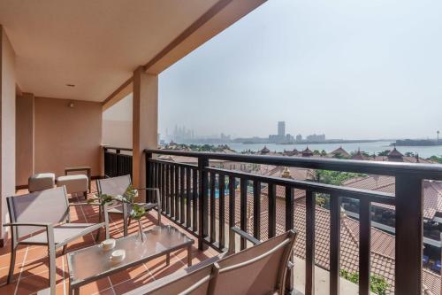 balcone con tavoli, sedie e vista sull'acqua di GuestReady - Slice of Luxury in Palm Jumeirah a Dubai