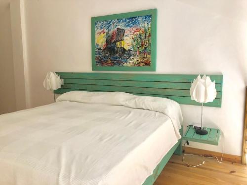 - une chambre avec un lit blanc et une peinture murale dans l'établissement Beach Day @CadaquesCaribe Bayahibe, à Bayahibe