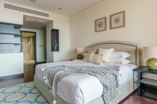 1 dormitorio con 1 cama grande y 1 mesa en GuestReady - Slice of Luxury in Palm Jumeirah en Dubái