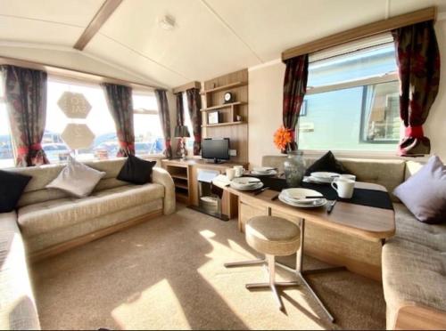 a living room with a couch and a table at Swift Loire (Field view 78) in Jaywick Sands