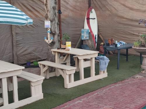 a tent with a table and a surfboard in it at Ay Jay's Guesthouse in Bloemfontein