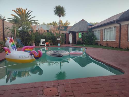 a swimming pool with a pool noodle toy in a house at Ay Jay's Guesthouse in Bloemfontein