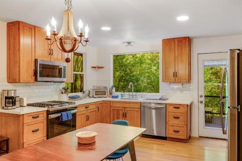 a large kitchen with wooden cabinets and a table at Caz Cabin 6 in Cazadero