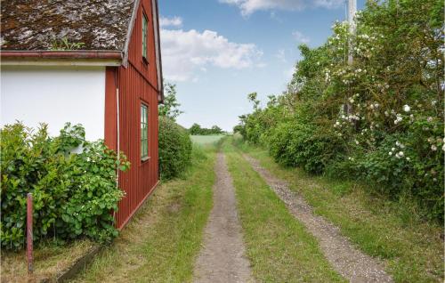 a dirt road in front of a red house at 3 Bedroom Beautiful Home In Fjälkinge in Fjälkinge