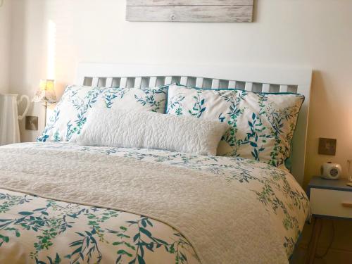 Cama con sábanas y almohadas azules y blancas en Sunsets, Sandylands Prom Morecambe, en Morecambe