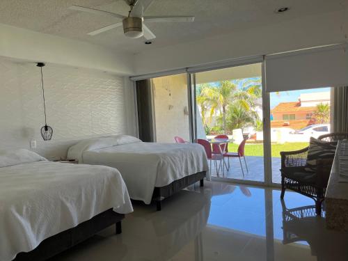 a bedroom with two beds and a view of a patio at Condominios Brisas Zona Hotelera in Cancún