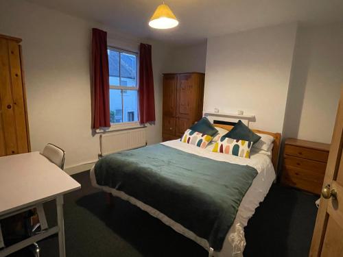 a bedroom with a bed and a desk and a window at Cozy 3 Bedrooms Home off Mill Road Sleep up to 6 in Cambridge