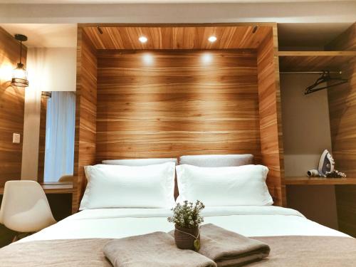 um quarto com 2 camas e uma cabeceira em madeira em Owl Nest Suite' at aeropod sovo em Kota Kinabalu