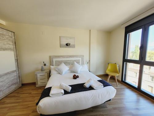 a bedroom with a large white bed with towels on it at Guest House Ainsa Pirineos in Aínsa