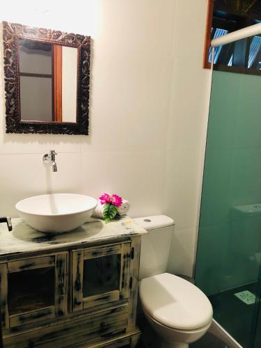 a bathroom with a sink and a toilet and a mirror at Shiva Guest House in Florianópolis