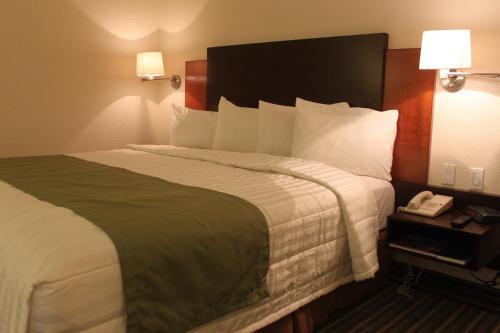 una habitación de hotel con una cama grande y un teléfono en Casa Grande Chihuahua, en Chihuahua