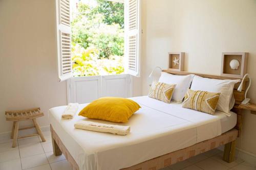 a bedroom with a large bed with a window at Domaine des Tourterelles in Capesterre