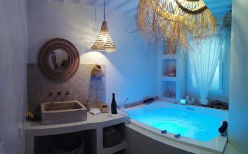 a bathroom with a large tub with a sink at La Petite perle, balnéo en supplément, le Clos des Perles in Tourtour
