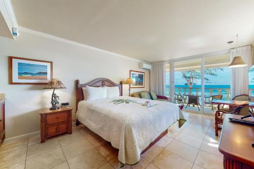 a bedroom with a bed and a view of the ocean at Islander on the Beach 354 in Kapaa