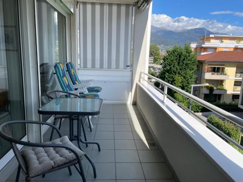 a balcony with chairs and a table and a view at Ascona: San Materno-Mary in Ascona
