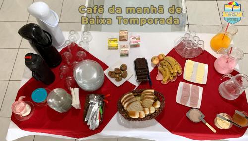 a red table with food and drinks on it at Hotel Paradyse Praia in Capão da Canoa