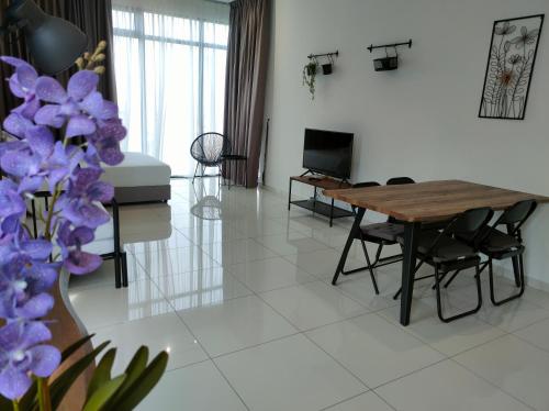 a living room with a table and purple flowers at New 2BR Georgetown Warm and Lovely Homestay 10pax-无敌美景两房民宿 Beacon Executive Suite in George Town