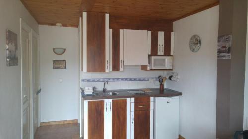 una cucina con mobili in legno e un lavello di Precioso apartamento de dos hab. en Calan Bosch a Ciutadella