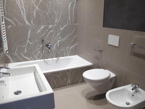 a bathroom with a white toilet and a sink at Alpine Mountain Chalet in San Vigilio Di Marebbe