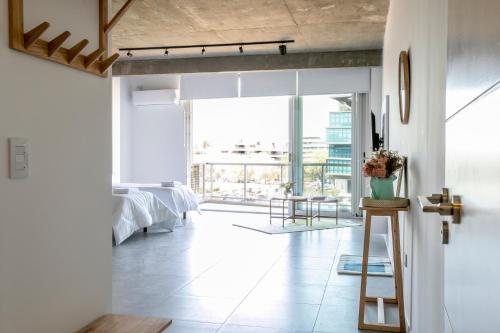 sala de estar con paredes blancas y ventana grande en Departamento premium en Pilar 220 en La Lonja