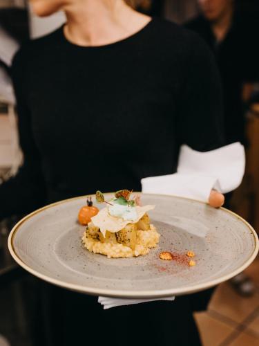 a woman is holding a plate with food on it at Hotel Dreiländerblick Dornbirn in Dornbirn