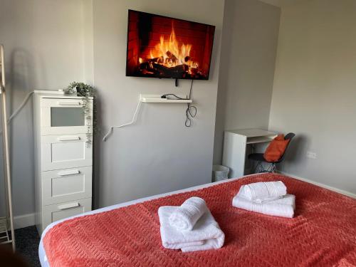 um quarto com uma cama com duas toalhas em Modern 4 Bedroom House 10 mins from East Croydon with Garden and Free parking em South Norwood