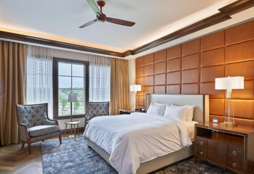 um quarto com uma cama grande e uma janela grande em The Inn at Meadowbrook em Prairie Village