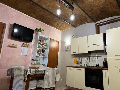 a kitchen with a table and a tv on a wall at L' anfora Locazione Turistica in Terni