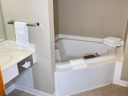 een badkamer met een bad en een wastafel bij Farmstead Inn and Conference Center in Shipshewana