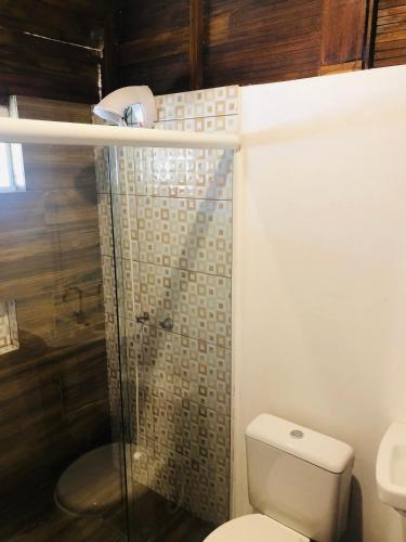 a bathroom with a toilet and a glass shower at Shiva Guest House in Florianópolis