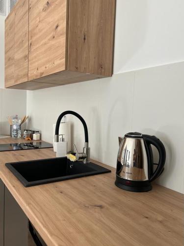 a kitchen counter with a sink and a tea kettle at Niron Apartamenty Królowej Jadwigi Złotów in Złotów
