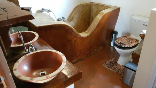 a bathroom with a copper tub and a toilet at Game Lodge bordering Kruger with splash pool in Phalaborwa