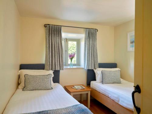 ein kleines Zimmer mit zwei Betten und einem Fenster in der Unterkunft Meavy Cottage in Totnes