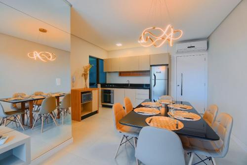a kitchen and dining room with a table and chairs at Apartamento Novinho, pertinho da Praia de Bombinhas in Bombinhas