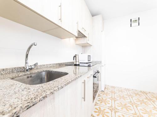 uma cozinha com um lavatório e um micro-ondas em Apartamento cerra playa em Gijón