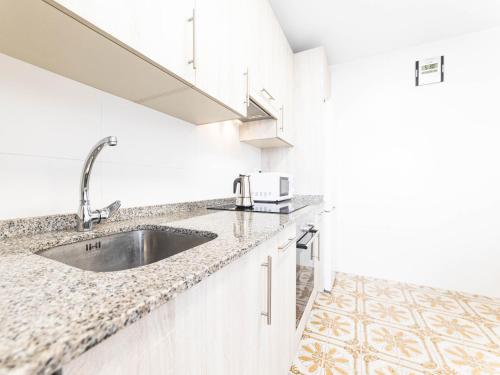a kitchen with a sink and a microwave at Apartamento cerra playa in Gijón
