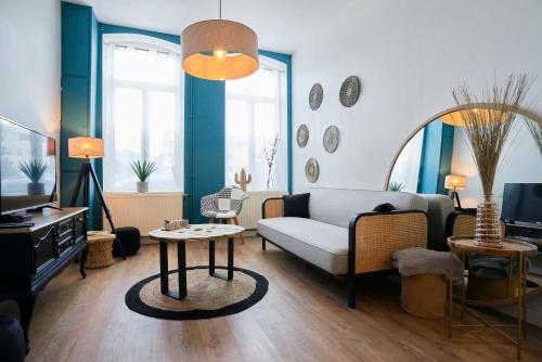 un soggiorno con divano e tavolo di Locations Tourcoing - Le Renaix a Tourcoing