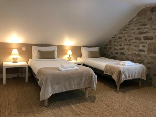 twee bedden in een kamer met twee tafels en twee lampen bij Gîtes Le Fer A Cheval Vassivière in Royère-de-Vassivière